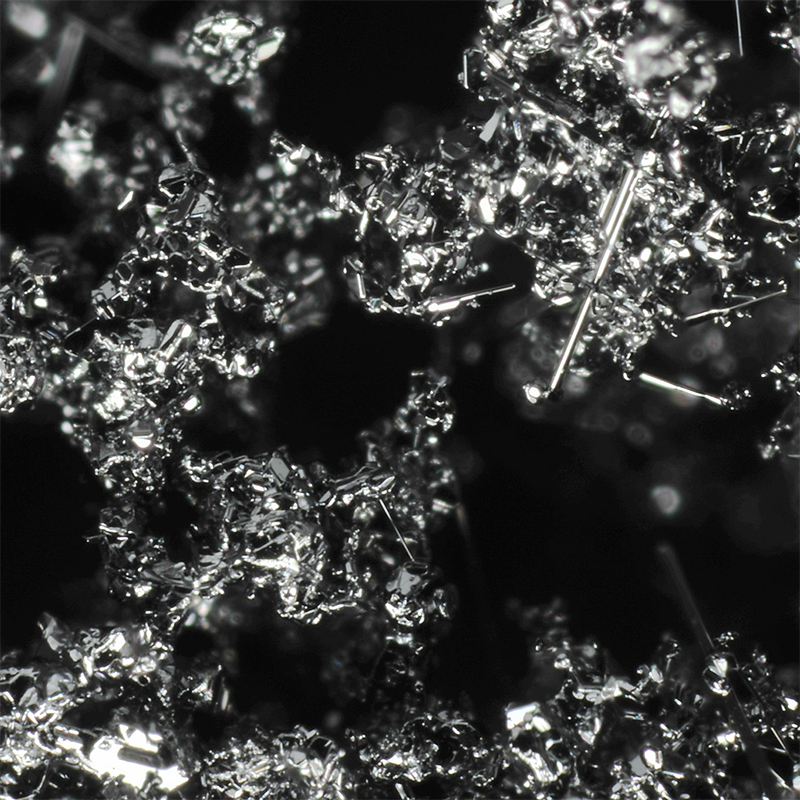 Close-up of metallic boron crystals representing the boron ingredient in the supplement on a dark background