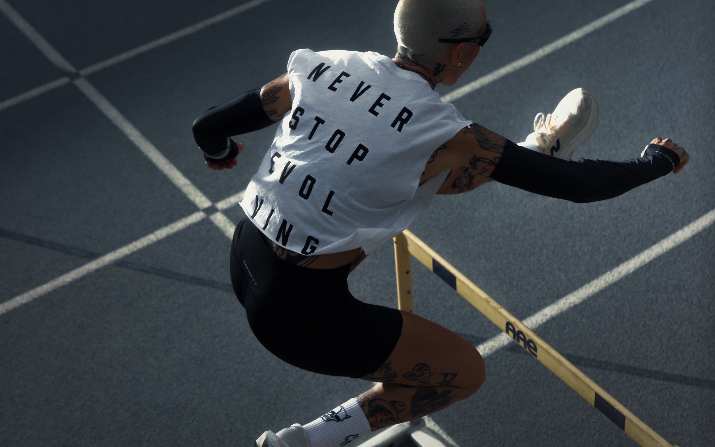 Female athlete hurdling on an outdoor track in midair, dynamic performance shot