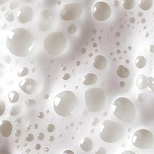 Close-up of creamy milk foam with glossy droplets representing milk protein isolate, a medium-digesting protein