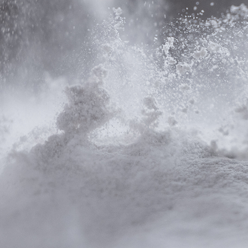 Burst of white protein powder in midair illustrating ProHydrolase digestive enzymes aiding protein digestion on gray background