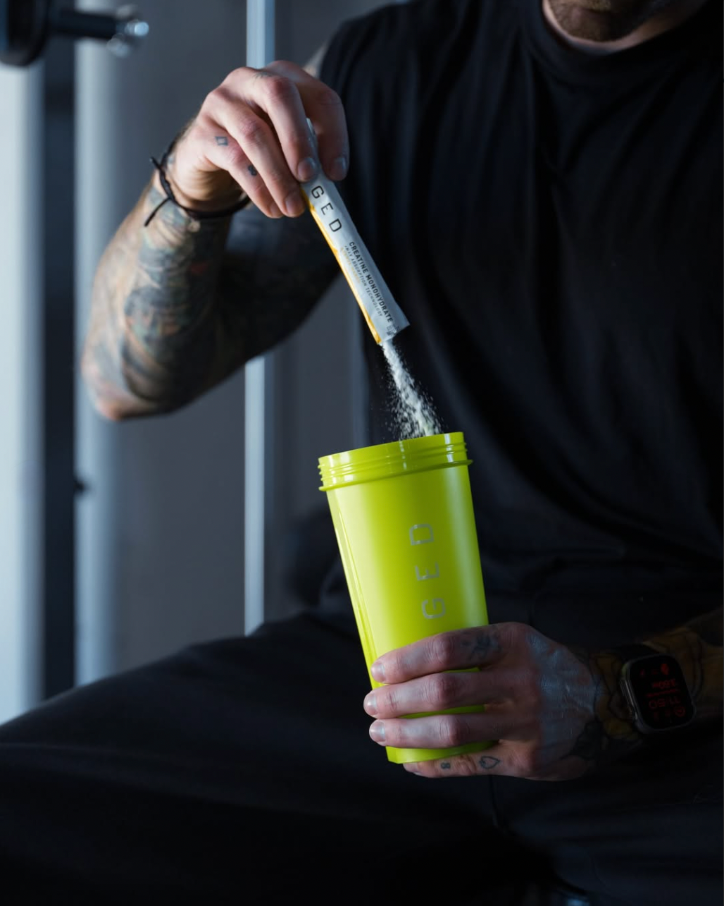 Close up of Creatine Monohydrate stick pack pouring powder into green KAGED shaker, showing single serve convenience